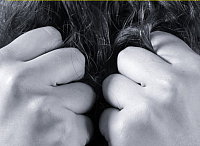 A teacher with dark hair pulling her hair in frustration